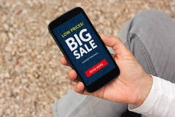 Hand holding smart phone with big sale concept on screen. All screen content is designed by me