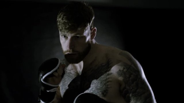  Muscular MMA fighters training together in dark environment
