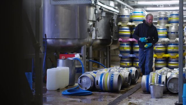  Worker in a brewery preparing barrels of beer