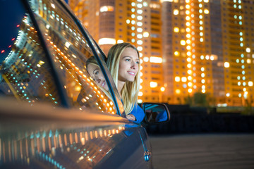 The girl in the car against the background of a building