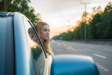 The girl in the car against the background of a road