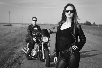 Fototapeta na wymiar Biker man and girl stands on the road
