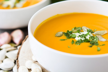 Pumpkin soup and ingredients on rustic wooden background


