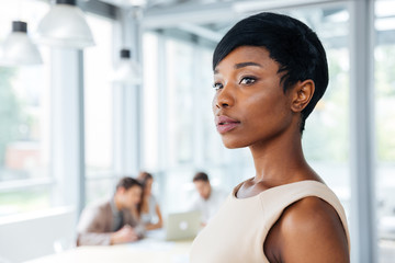 Serious beautiful african american young businesswoman standing in office