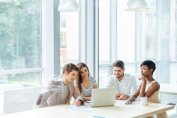 Fototapeta premium Happy business team working with laptop together in office
