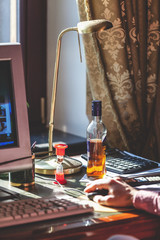 alcohol Bottle and desk lamp on desktop