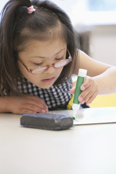 Mixed race Down syndrome student drawing in class