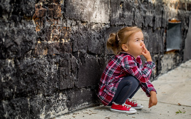 little beautiful girl near brick wall