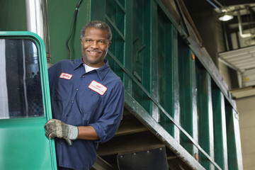 African mechanic standing on dump truck