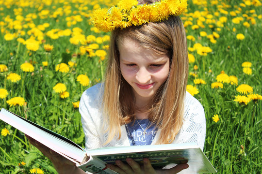 young girl on the dandalion meadow