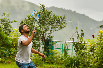 Indian playing badminton in green garden