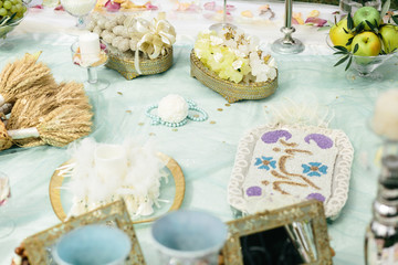 Paper balls and blue necklaces lie on a table with sweets