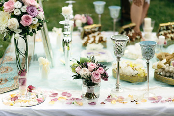 Roses, candleholders and silver glasses beautify a table with sw