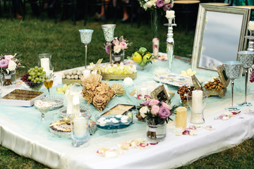 A look from afar on the pastry lying between candles and roses o
