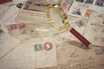 Vintage old mails, postage stamps, postcards and magnifying glass, grunge textured