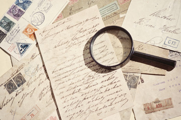 Vintage old mails, postage stamps, postcards and magnifying glass, grunge textured