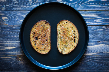Food composition made of 2 slices of toasted bread in a black pan