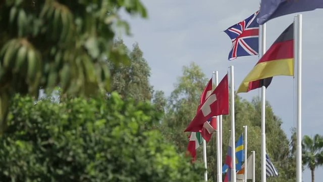 Lots of flags of different countries fluttering in the wind