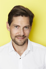 Portrait of smiling man on yellow background