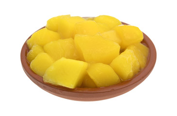 Diced mangoes in a small dish on a white background.