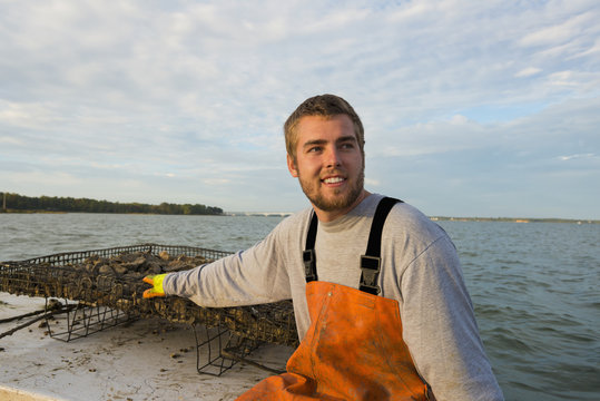 Caucasian fisherman holding net on boat