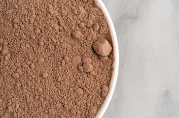 Devil's food cake mix in a white bowl on a gray marble counter top.