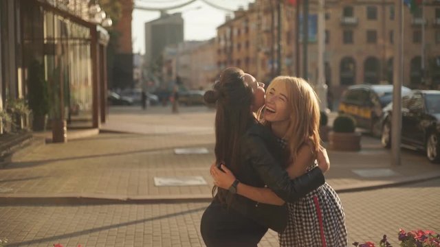 Slow Mo Happy meeting of two friends hugging in the street