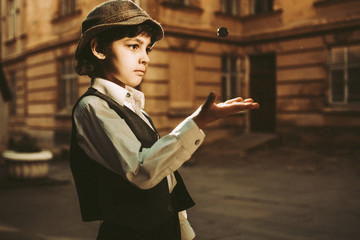 Caucasian boy wearing old-fashioned clothing tossing marble
