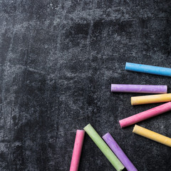 Pieces of school chalk on old black chalkboard