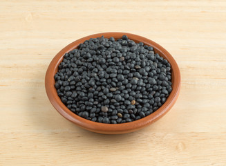 Fototapeta na wymiar Black beluga lentils in a bowl on a table.