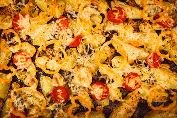 roasted potatoes with cheese, peppers,  mushroom, tomatoes, Close-up. View from above. Horizontal