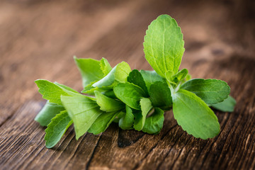 Wooden table with Stevia leaves (selective focus) - obrazy, fototapety, plakaty