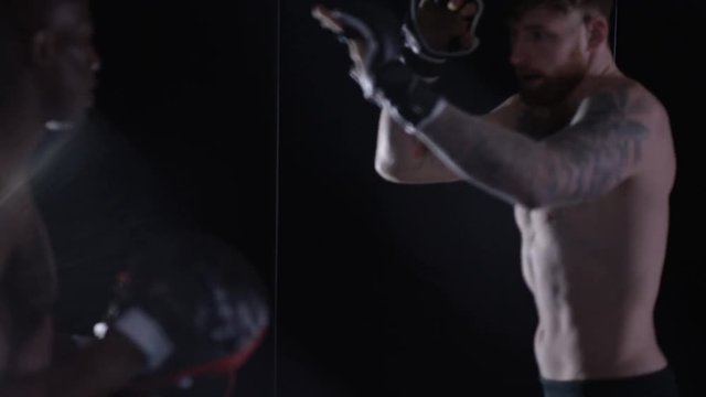 Muscular MMA fighter training with partner in dark environment