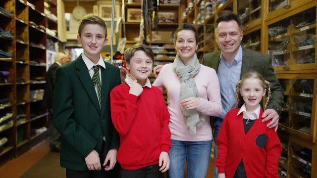  Portrait family with children trying on new school uniforms in clothing store