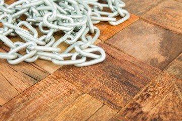 Steel chain on wooden background. Macro shot.