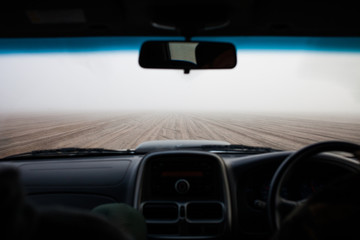 View of foggy beach from inside a car, Namibia