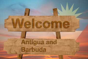 Welcome to Antigua and Barbuda sing on wood background with blending national flag
