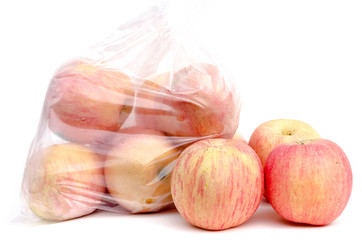 The heap of red apples packed in plastic film on white background