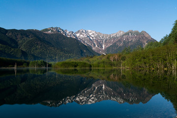 Fototapeta premium Wczesny poranek na wiosnę Kamikochi Taisho-ike staw, nagano, japonia