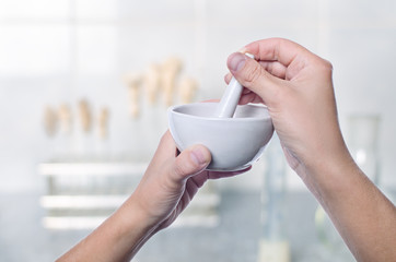 Scientist using pestle and mortar in laboratory