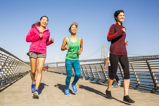 Women running on urban footbridge, San Francisco, California, United States