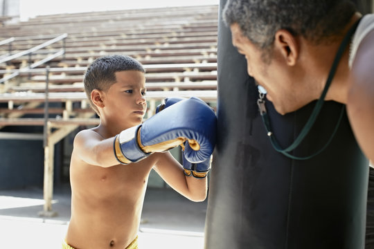 Hispanic boy boxing punching bag