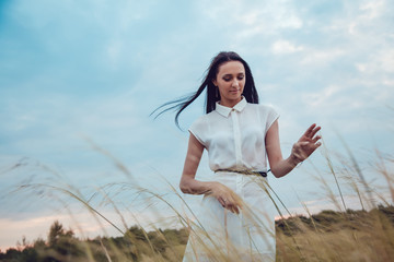 Obraz premium The beautiful brunette walks into the field