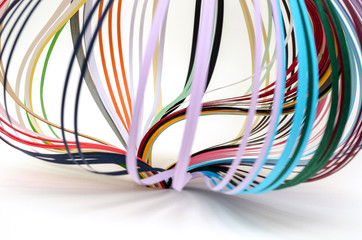 Colorful paper filigree strips in waves on white background
