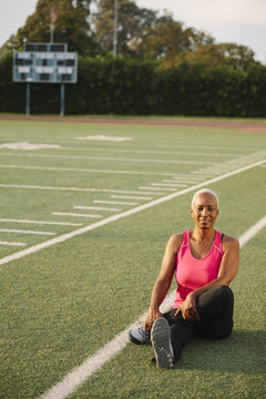 Woman stretching on football field