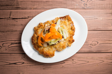 schnitzel in crackers breaded on white plate