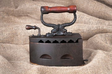 The old coal iron on a fabric background