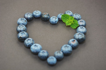 On a dark background lined with blueberries in a heart shape.