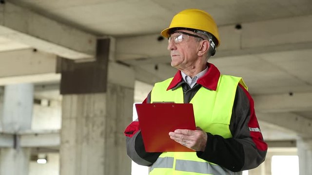 Engineering supervision. Supervisory personnel at construction site. Job inspector in yellow hard hat at project site