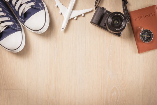 Flat lay of travel planning and equipment necessary on wooden floor background - Holiday travel concept.